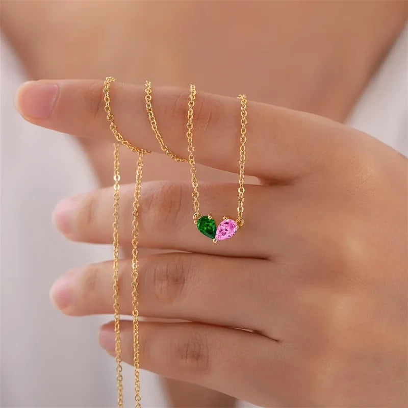 Heart necklace with two stones held in a hand